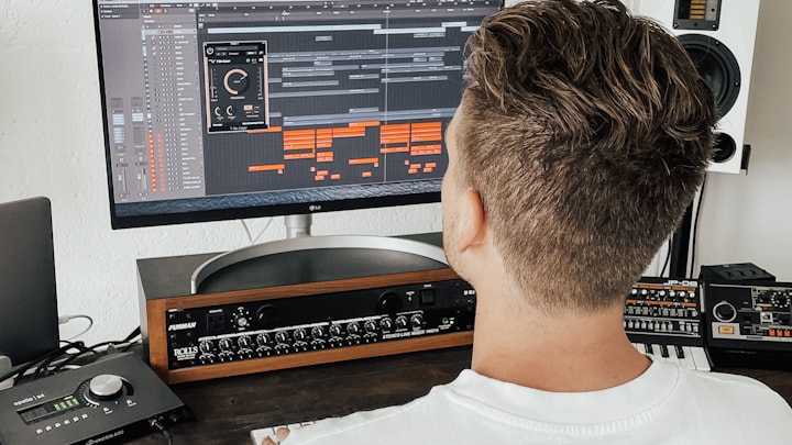 Music producer working at a computer in a professional studio setup — the digital infrastructure behind an artist's career matters as much as the music itself